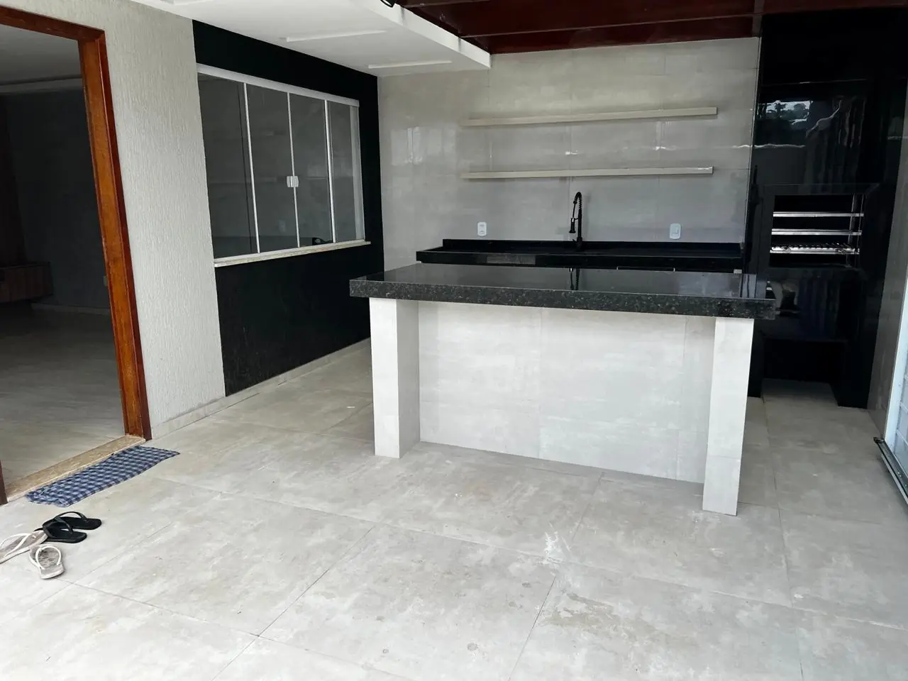 Cozinha renovada com ilha e bancada em pedra escura